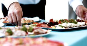 Man grabbing charcuterie tray from table