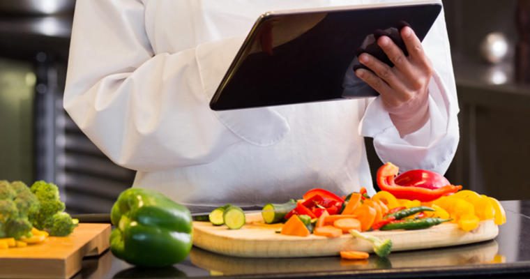 Kitchen worker using a tablet to manage data