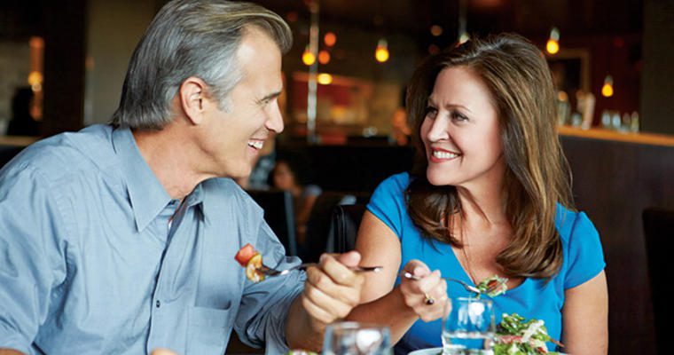 Middle aged man and woman eating