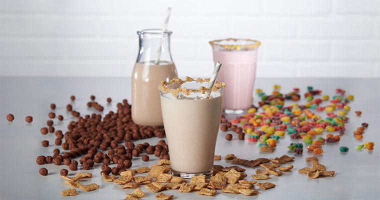 Cereal-infused milk with cereal scattered around the glasses