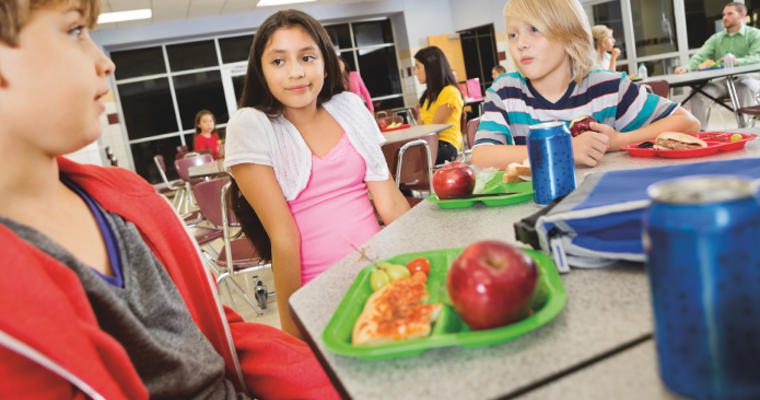 Students eating healthy foods in a cafeteria setting