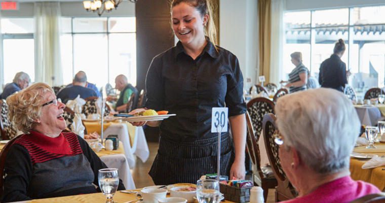 Waitress serving food to older women