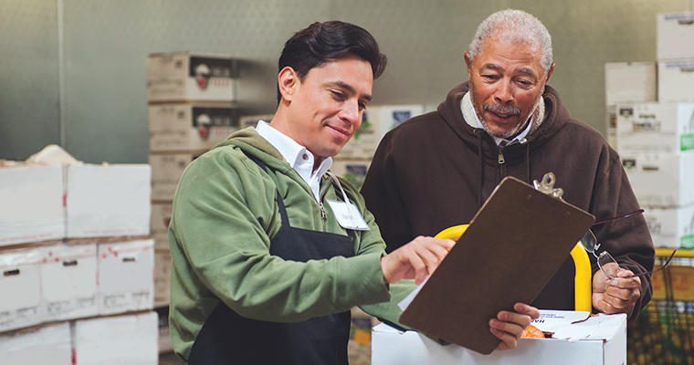 Man showing clipboard to working to worker