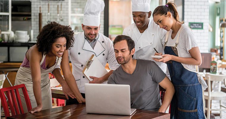 Restaurant staff looking at a laptop together