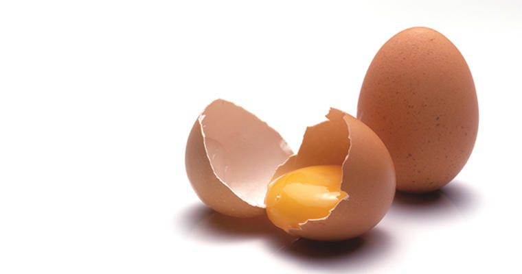 A broken egg next to a whole egg