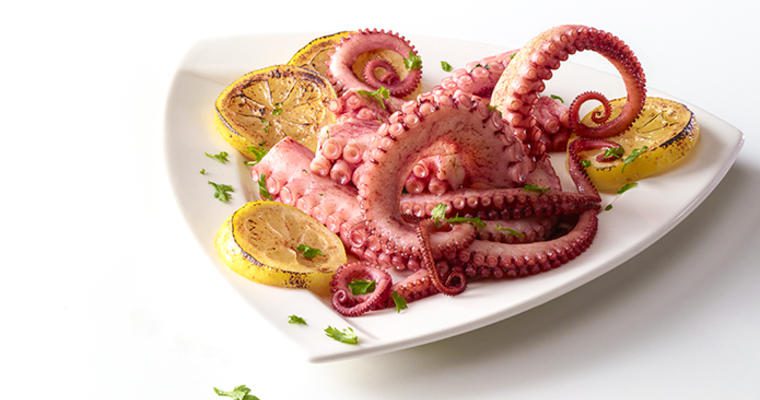 A plate of octopus with lemon slices