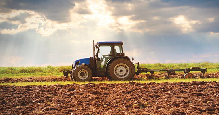 A tractor plows a field for planting