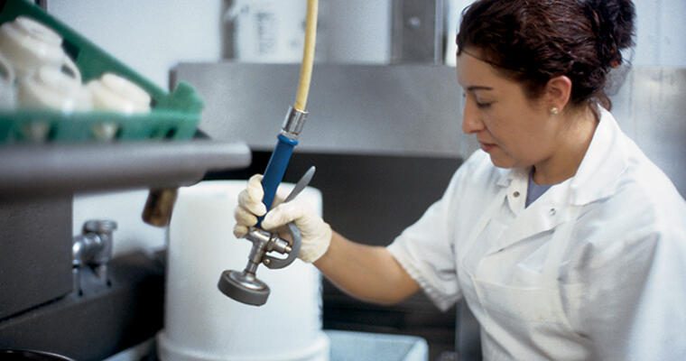 Food service working using proper techniques to sanitize surfaces and keep their work space clear from food borne illnesses.