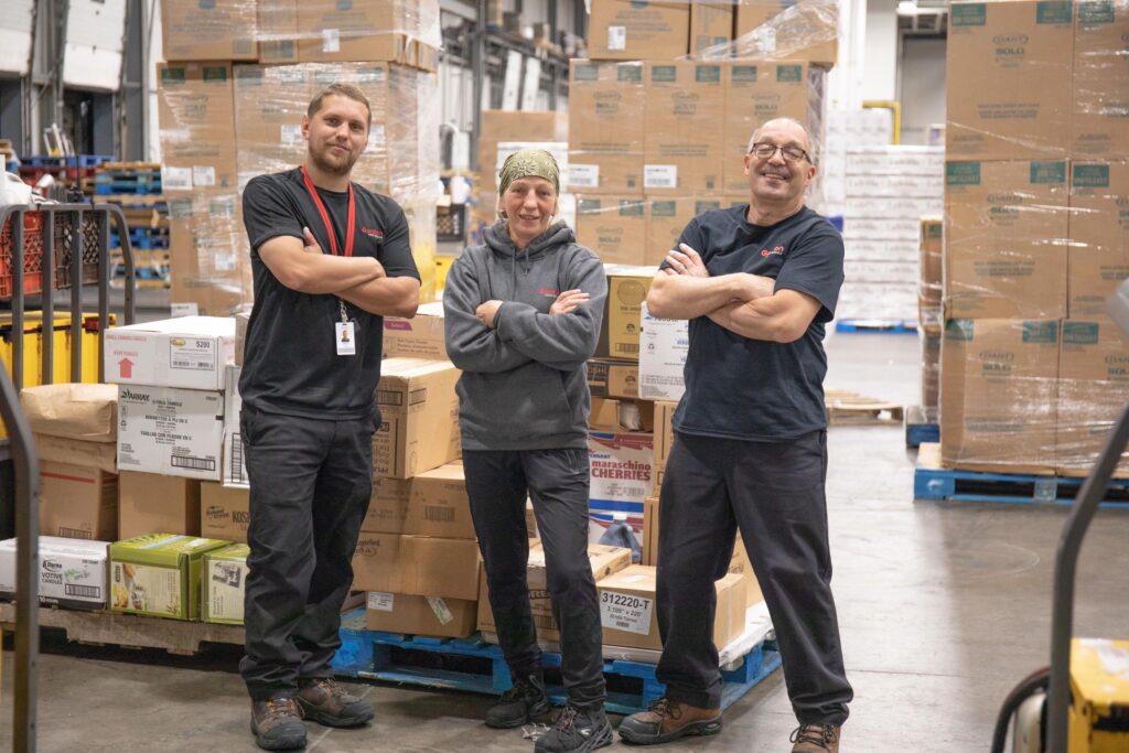 Employees posing for photo in distribution center.