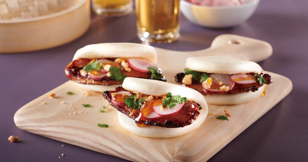 BBQ Pork Belly Bao Buns served on a wooden board
