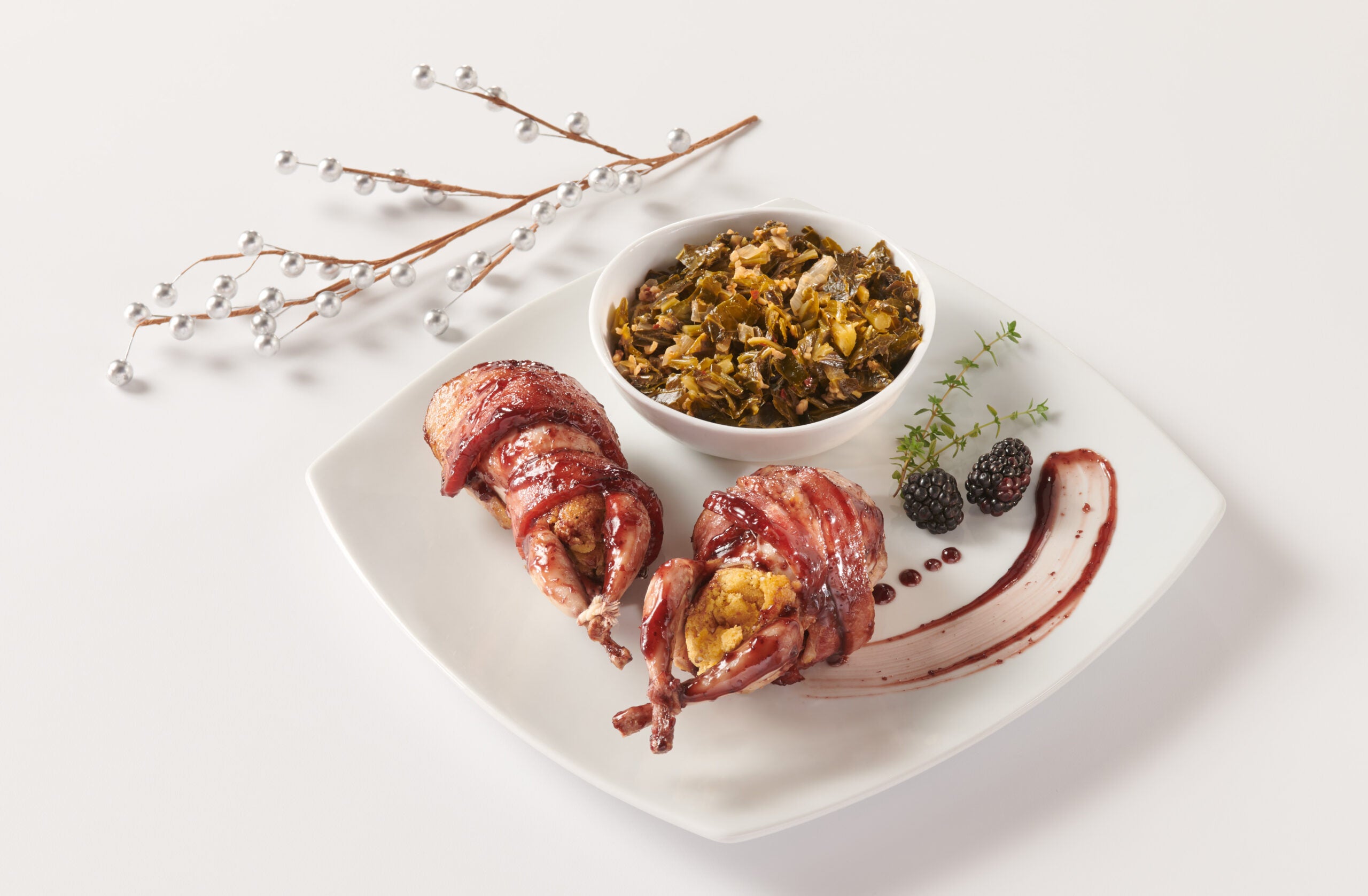 Bacon wrapped wildfowl on a white dish themed for the holidays.