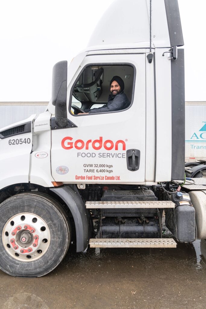 Truck driver in the truck , smiling down from the seat