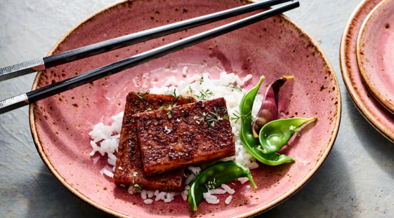 Dish served in large vibrant colors restaurant dinnerware bowl with chopsticks sitting on the edge