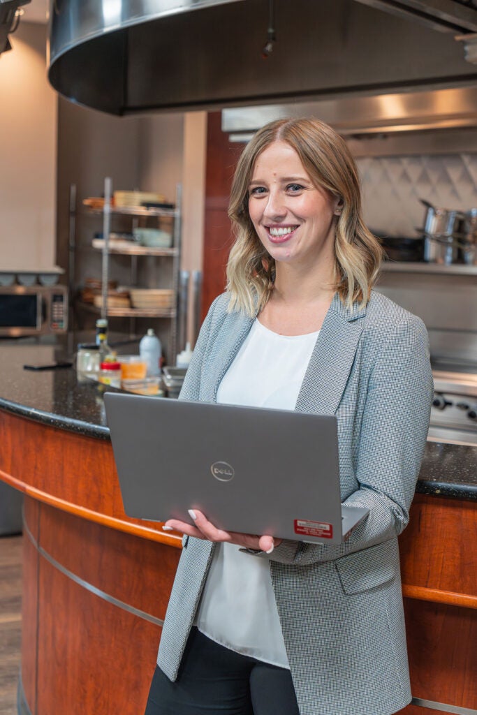 GFS sales rep holding a laptop.