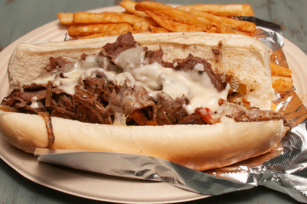 A Beef bulgogi hoagie on a disposable plate with tin foil.